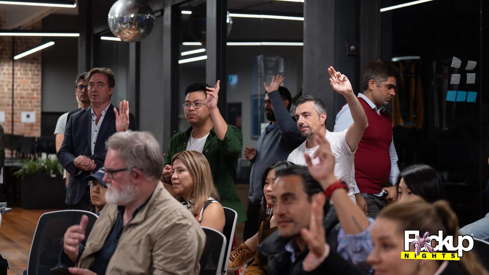 An audience listening and asking questions at a community storytelling event
