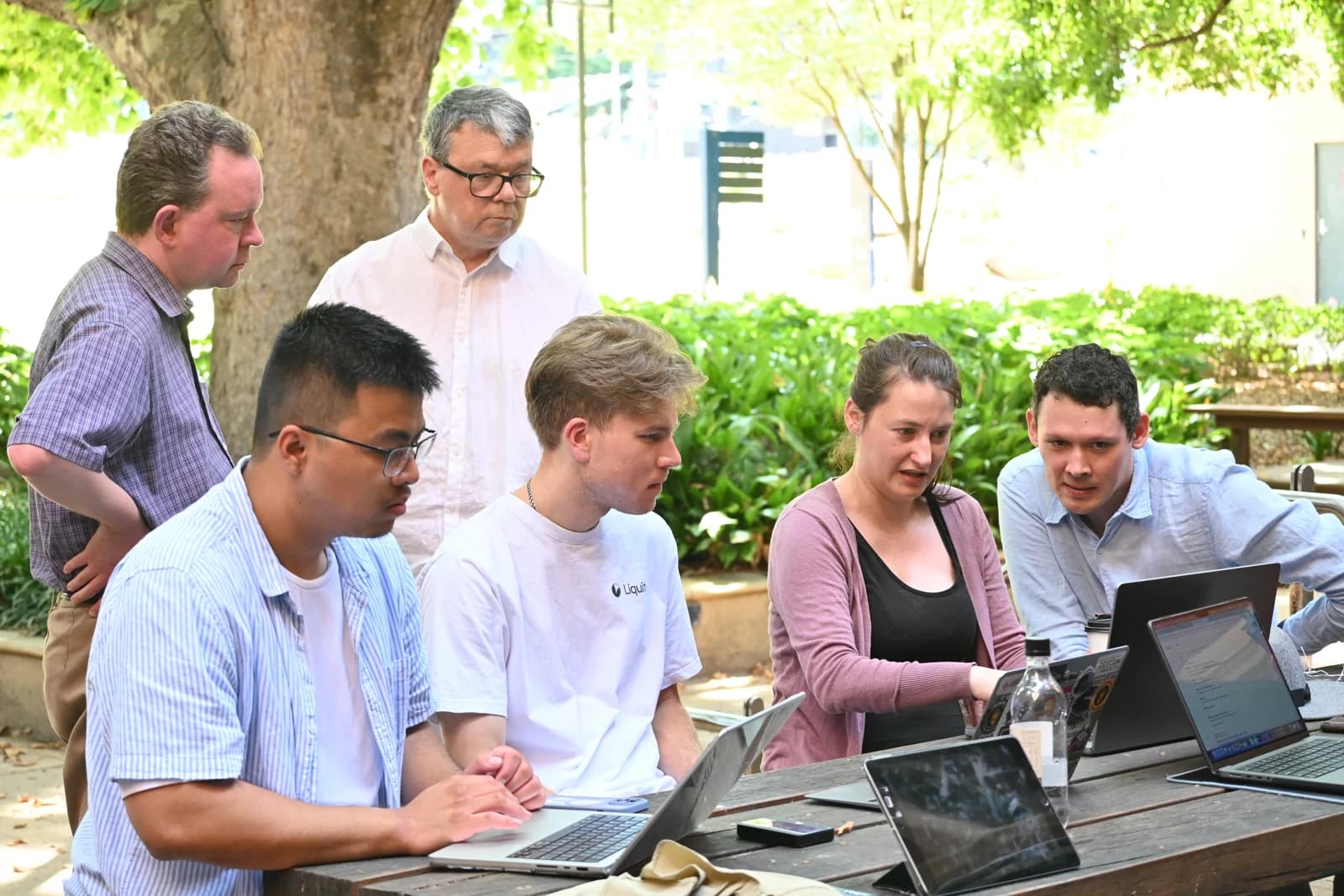 Developers working together around laptops at a community meetup